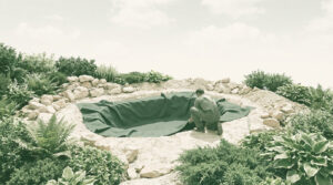 Un homme installe une bâche d'étanchéité noire dans un trou creusé dans le sol pour créer un bassin de jardin.